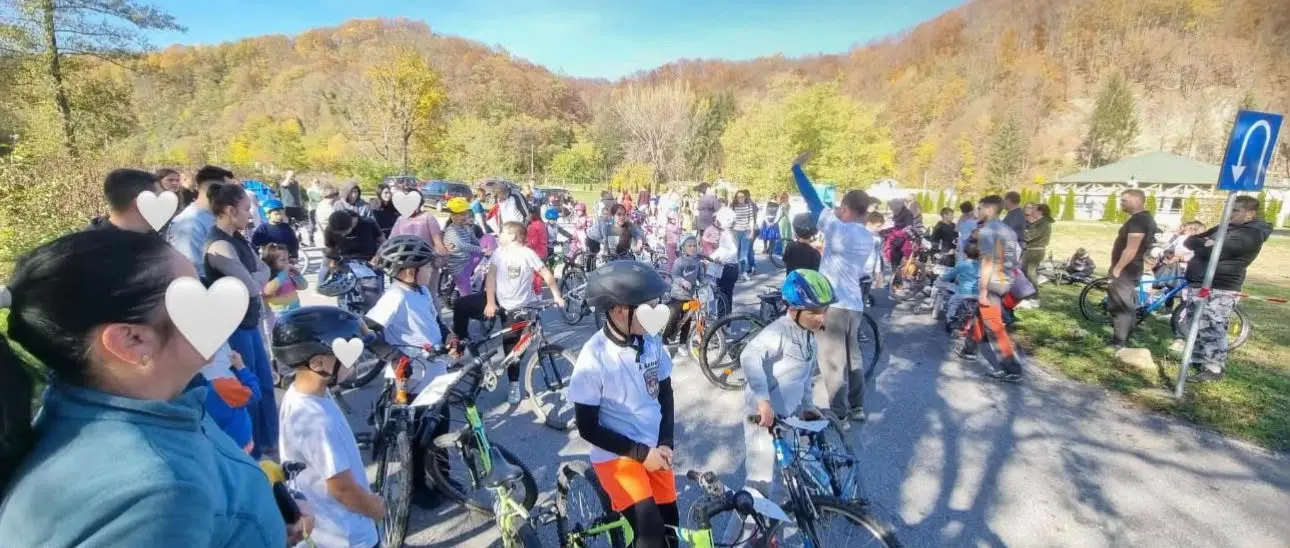 Zeci de copii pe biciclete la Cursa Viselor, cu dealurile de toamnă în spate